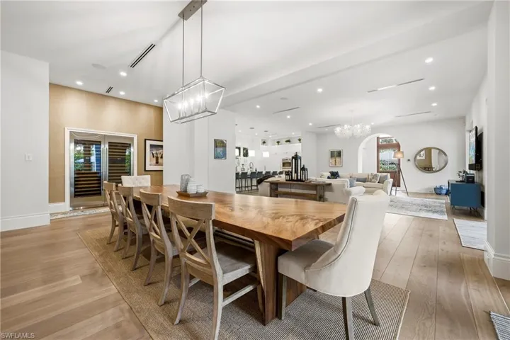Dining area featuring suspended lighting, light wood finished floors, and arched walkways