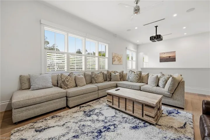 Living room with wood finished floors, a ceiling fan, and recessed lighting