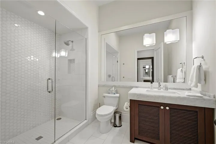 Bathroom with vanity, a stall shower, and light tile patterned flooring