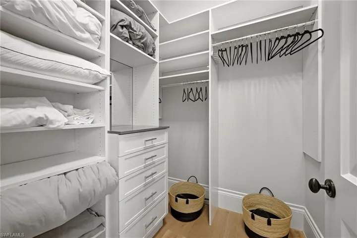 Walk in closet with light wood-type flooring