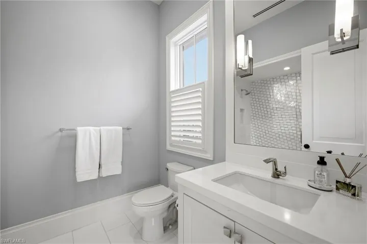 Bathroom with vanity, light tile patterned flooring, and a shower