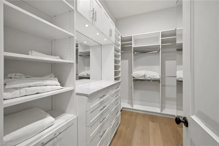 Walk in closet with light wood-type flooring