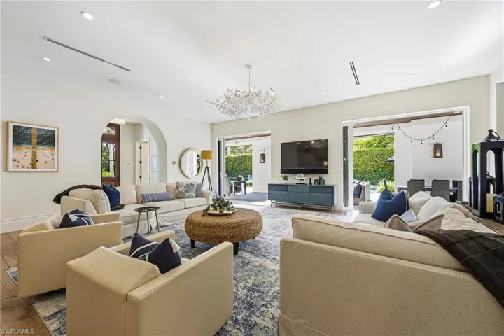 Living room featuring hanging lights, arched walkways, plenty of natural light, and wood finished floors