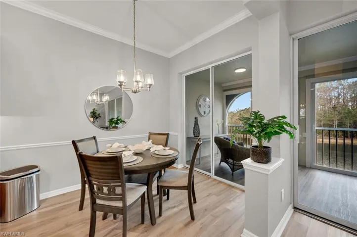 Dining space with a wealth of natural light, light hardwood / wood-style floors, and a chandelier