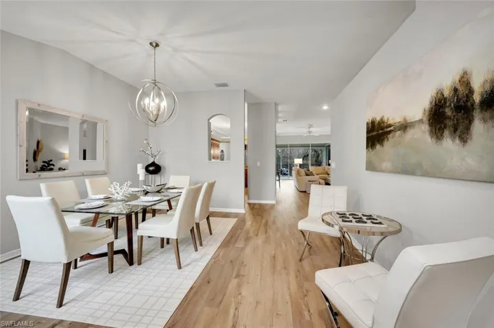 Dining area featuring ceiling fan with notable chandelier and light wood-type flooring
