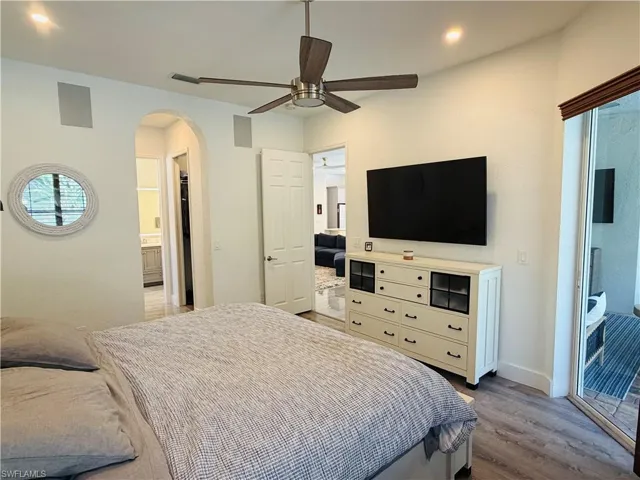 The room features a ceiling fan, recessed lighting, and a sliding glass door
