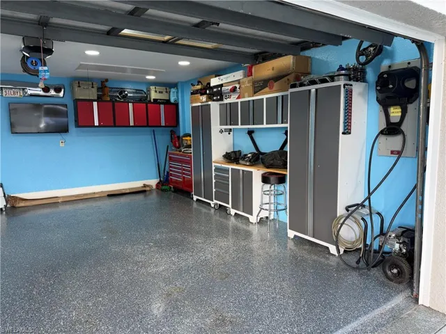 The property features a garage with a speckled epoxy floor, overhead lighting, and built-in storage cabinets