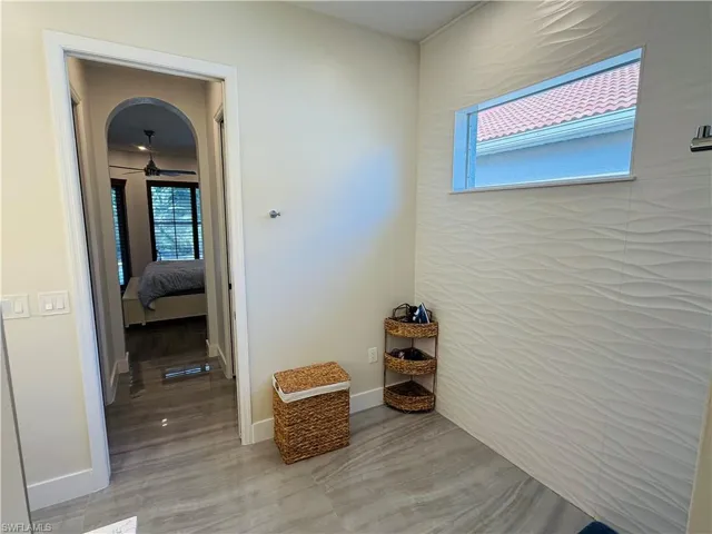 This room features light-colored walls, a window, and grey tiled flooring