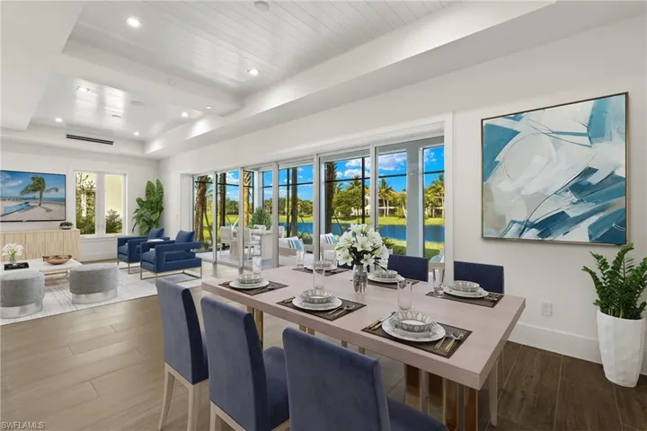 Dining area with a tray ceiling, porcelain tile flooring, and a water view