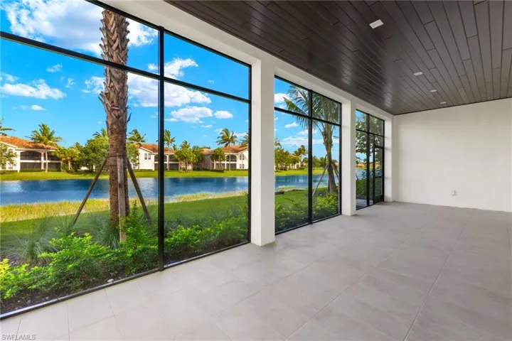 Unfurnished view of lanai featuring wood ceiling, wiring for ceiling fans and a water view