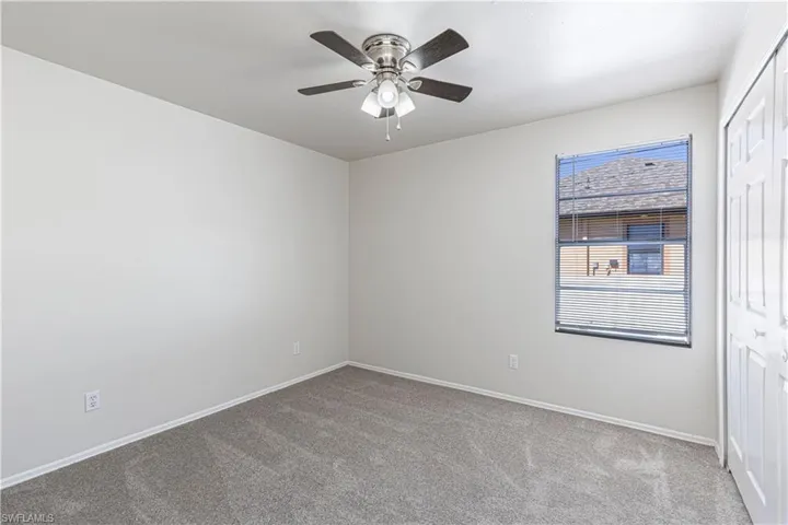 Unfurnished room featuring light colored carpet and ceiling fan