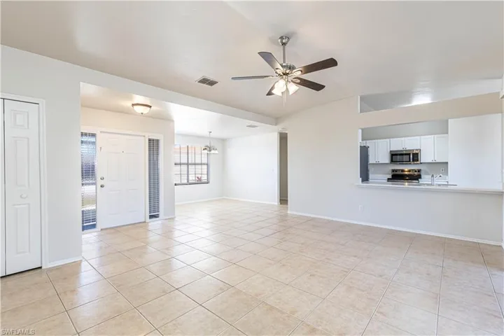 Unfurnished living room featuring a ceiling fan and light tile patterned flooring