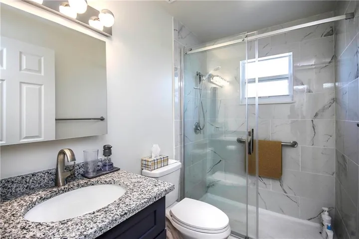 Bathroom with a shower stall, vanity, and toilet