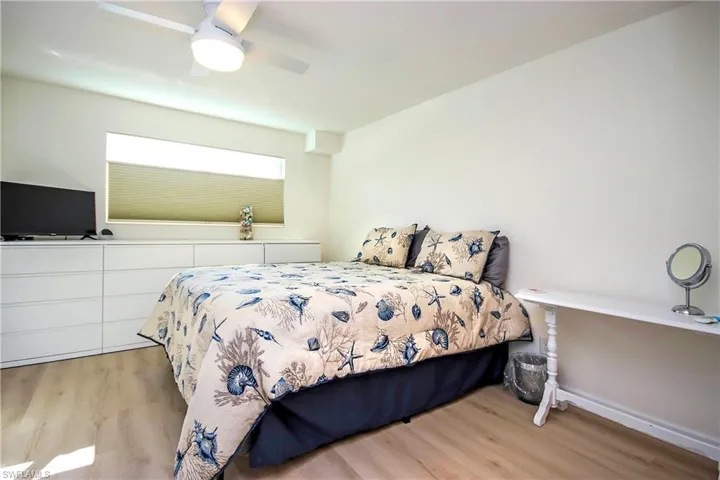 Bedroom featuring light wood finished floors, ceiling fan, and baseboards