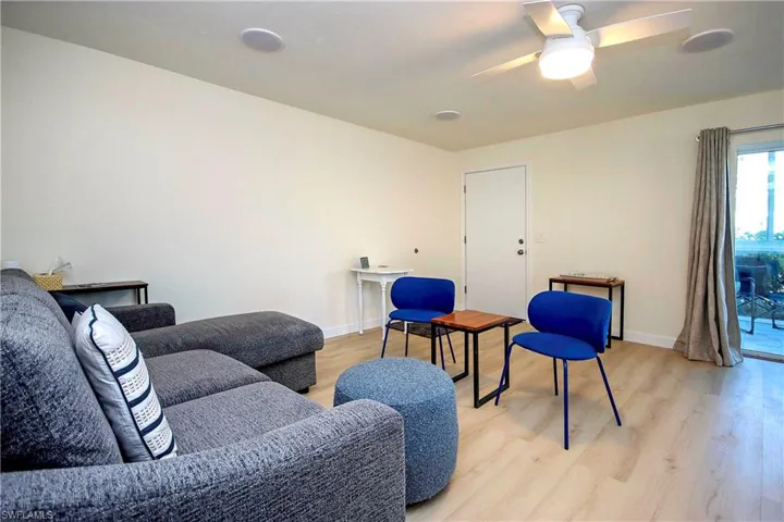 Living area with ceiling fan, light wood-style floors, and baseboards