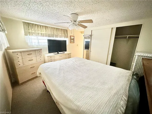 Bedroom with carpet, ceiling fan, and a closet