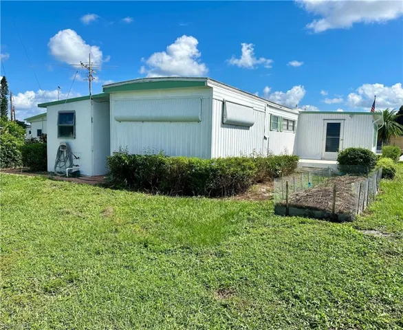View of side of property featuring a lawn