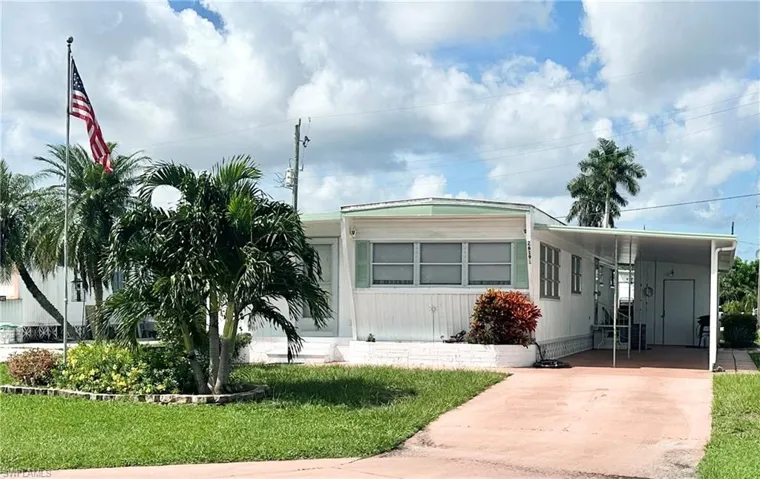 Manufactured / mobile home with a carport and a front lawn