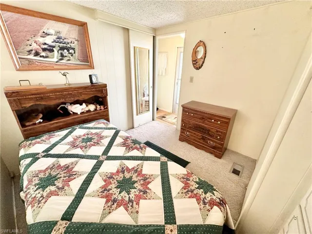 Bedroom with carpet and a textured ceiling