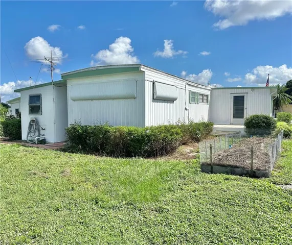 View of side of property featuring a lawn
