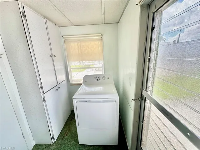 Clothes washing area featuring washer / clothes dryer and a textured ceiling