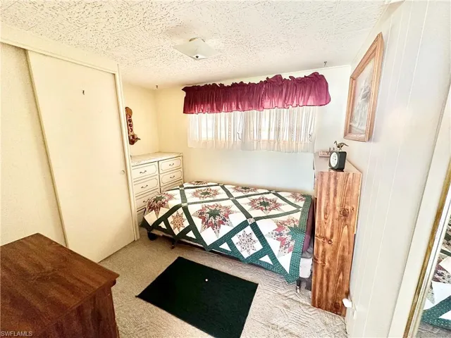 Carpeted bedroom featuring a textured ceiling