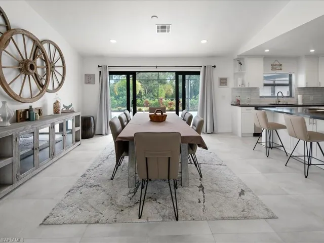 Tiled dining room featuring sink and lofted ceiling