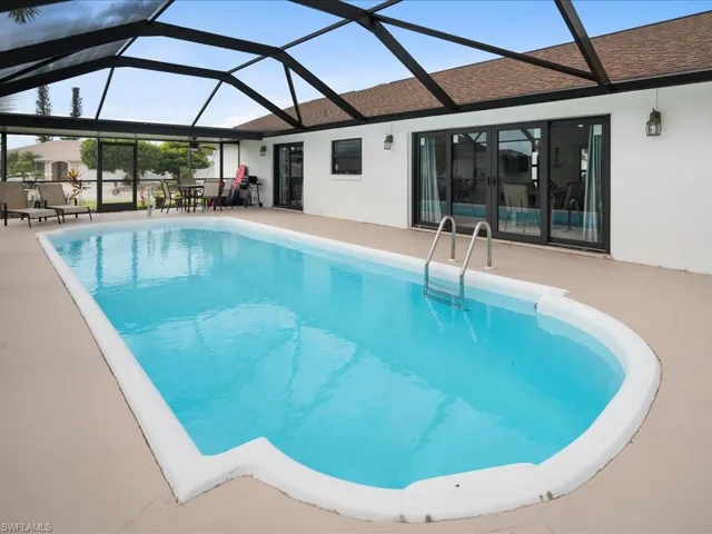 View of swimming pool with a patio and glass enclosure