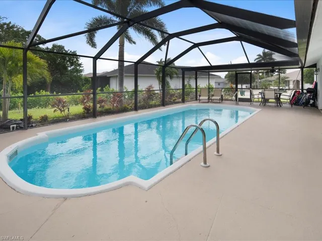 View of swimming pool featuring a patio and glass enclosure