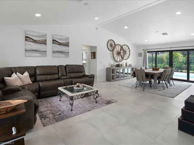 Tiled living room featuring vaulted ceiling