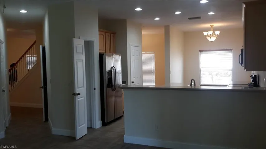 Kitchen with appliances with stainless steel finishes, a peninsula, recessed lighting, and hanging light fixtures