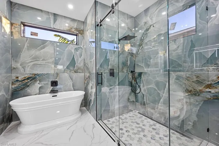 Bathroom featuring tile walls and plus walk in shower