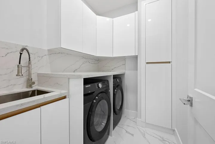 Laundry room featuring cabinets, independent washer and dryer, and sink