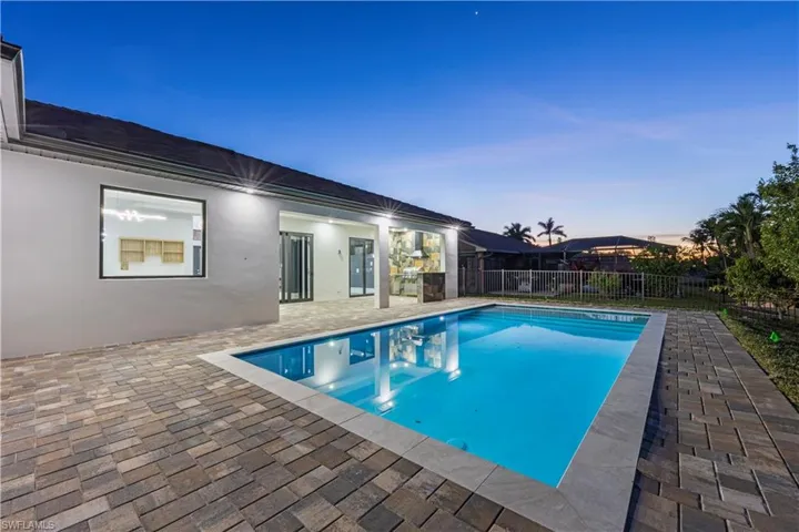 Pool at dusk featuring a patio area