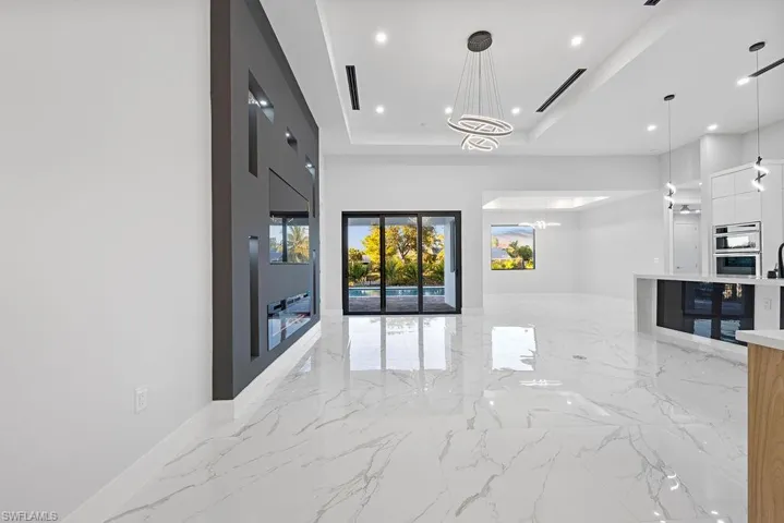 Hall with an inviting chandelier and a raised ceiling