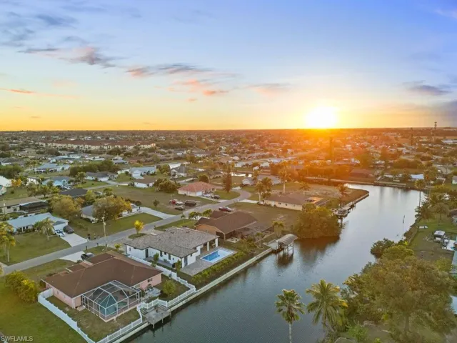 Aerial view at dusk featuring a water view