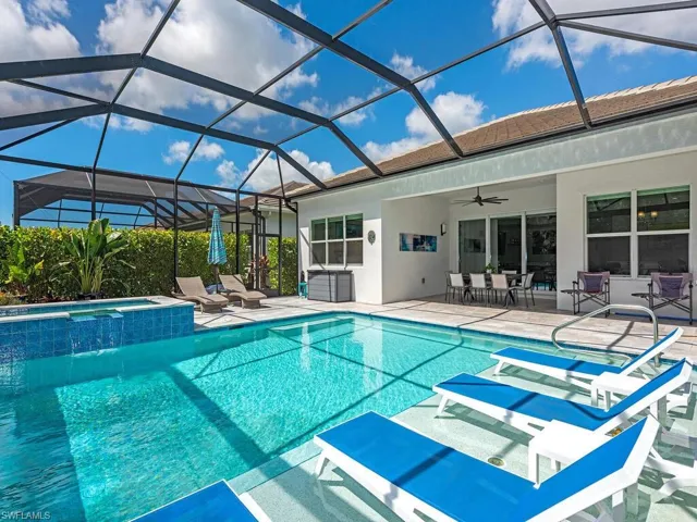 View of pool with a sunroom, a patio, a ceiling fan, and a pool with connected hot tub