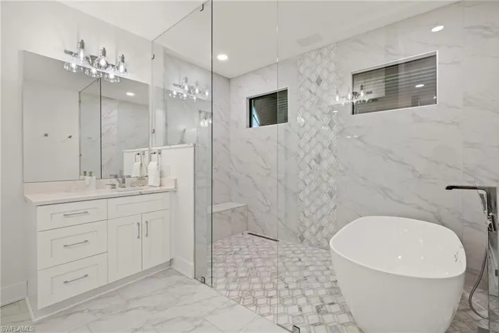 Bathroom featuring vanity and separate shower and tub
