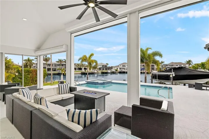 View of swimming pool featuring a water view, an in ground hot tub, outdoor lounge area, and a patio area
