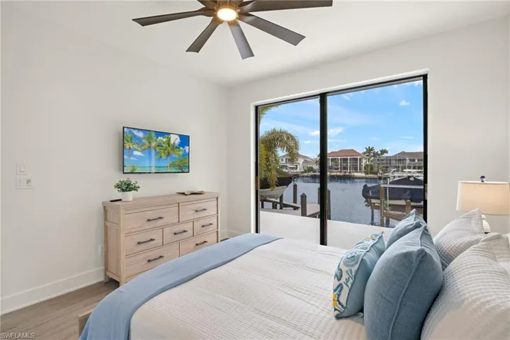 Bedroom with ceiling fan, light hardwood / wood-style floors, and access to outside