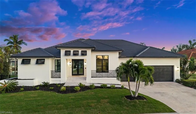 View of front of property with a garage and a yard