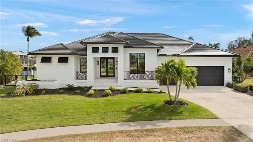 View of front facade with a garage and a front lawn