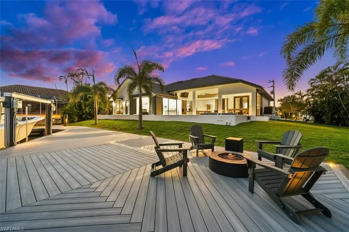 Deck at dusk with a lawn and a fire pit