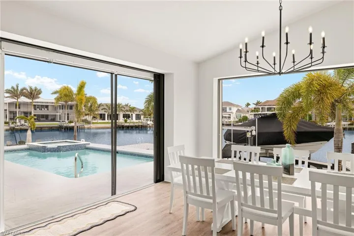 Dining area featuring vaulted ceiling, a water view, wood-type flooring, and a wealth of natural light