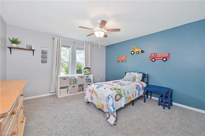 Bedroom with light colored carpet and ceiling fan