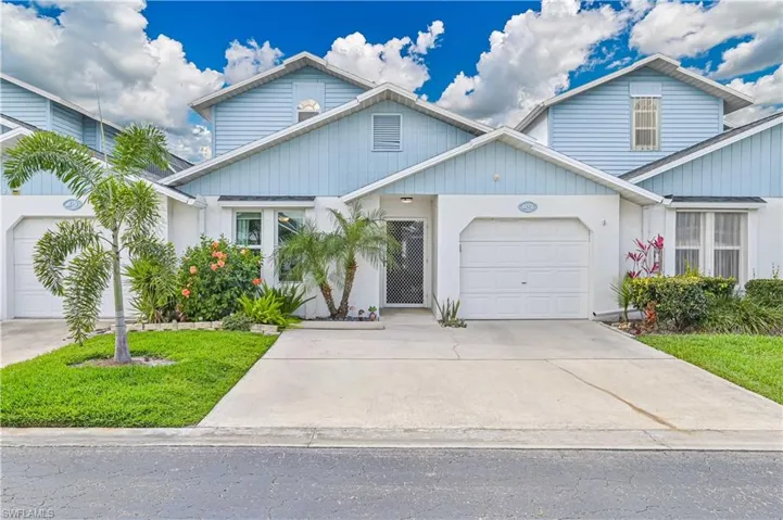 Traditional-style home with concrete driveway, a garage, and a front yard
