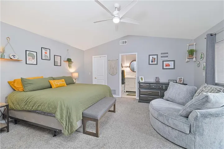 Carpeted bedroom with a ceiling fan and connected bathroom