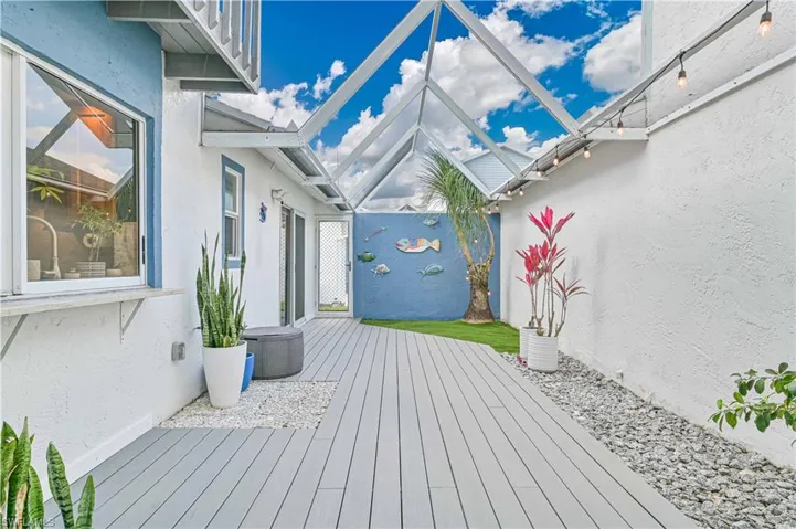 Deck featuring glass enclosure and a sunroom