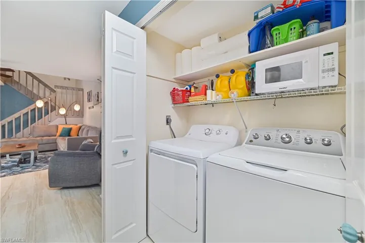 Laundry area with light wood-style flooring and separate washer and dryer