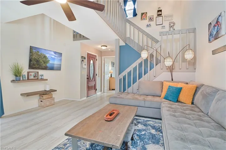 Living room featuring a high ceiling, wood finished floors, and a ceiling fan